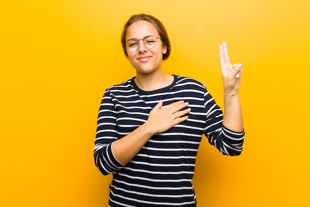 l'air heureux, confiant et digne de confiance, souriant et montrant le signe de la victoire, avec une attitude positive