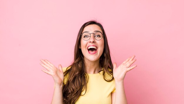 L'air heureux et excité choqué par une surprise inattendue avec les deux mains ouvertes à côté du visage