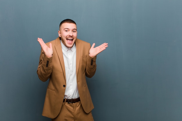 l'air heureux et excité, choqué par une surprise inattendue avec les deux mains ouvertes à côté du visage