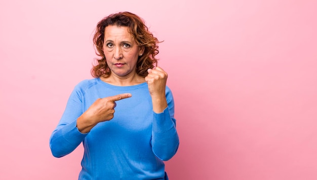 L'air impatient et en colère pointant vers la montre demandant la ponctualité veut être à l'heure