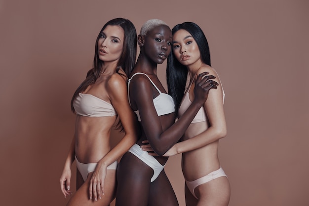 Photo l'air parfait. trois jolies femmes métisses regardant la caméra