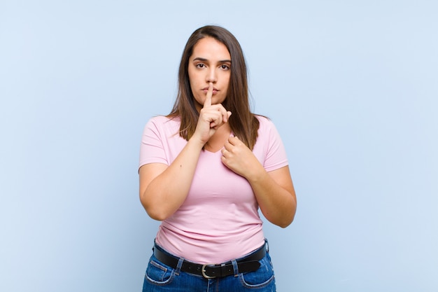 l'air sérieux et croisé avec le doigt pressé sur les lèvres exigeant le silence ou le calme, gardant un secret