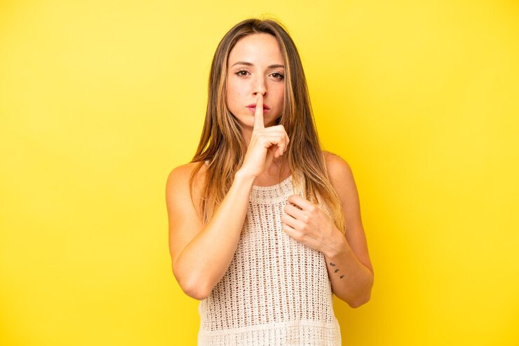 Photo air sérieux et croisé avec le doigt pressé sur les lèvres exigeant le silence ou le silence gardant un secret