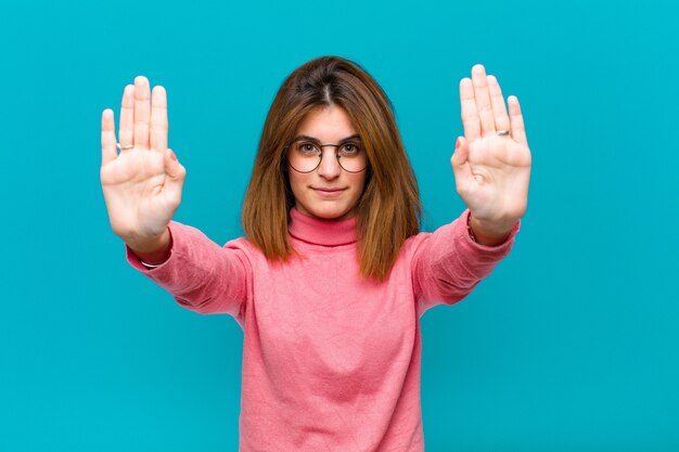 l'air sérieux, malheureux, en colère et mécontent interdisant l'entrée ou disant arrêt avec les deux paumes ouvertes