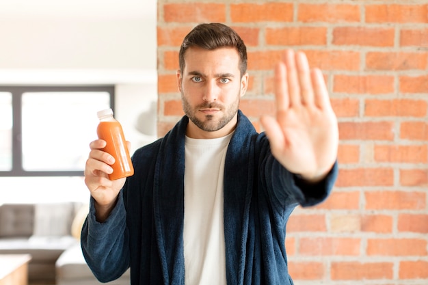 l'air sérieux, sévère, mécontent et en colère montrant la paume ouverte faisant un geste d'arrêt