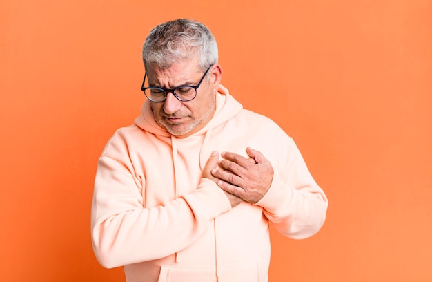 L'air triste, blessé et le cœur brisé, tenant les deux mains près du cœur, pleurant et se sentant déprimé