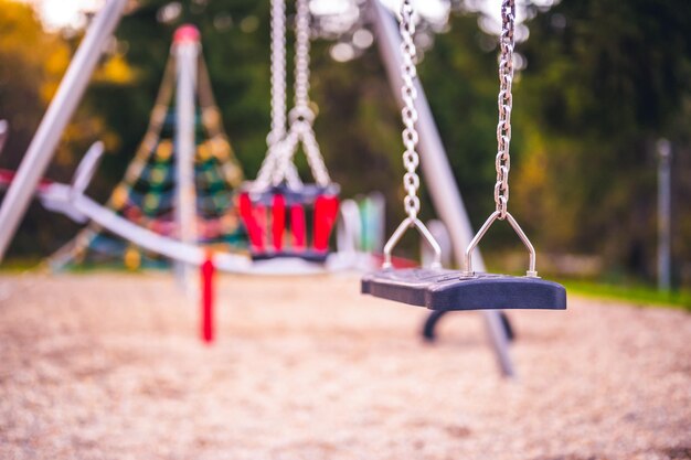 Aire de jeux colorée sur cour dans le parc Activités de jeux pour enfants colorés dans un parc public entouré d'arbres verts