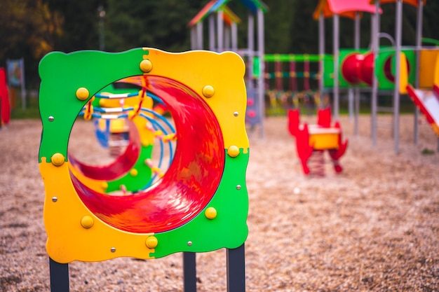 Aire de jeux colorée sur cour dans le parc Activités de jeux pour enfants colorés dans un parc public entouré d'arbres verts