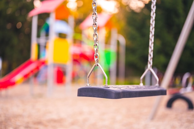 Aire de jeux colorée sur cour dans le parc Activités de jeux pour enfants colorés dans un parc public entouré d'arbres verts