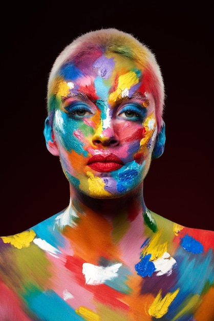 Ajouter de la couleur fait toute la différence Prise de vue en studio d'une jeune femme posant avec de la peinture multicolore sur son visage