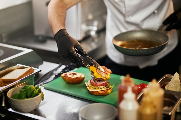 Ajouter du bœuf à un cheeseburger dans une cuisine professionnelle