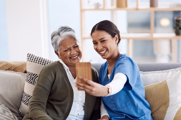 Ajouter du plaisir à leurs journées ensemble Photo d'une jeune infirmière prenant des selfies avec une femme âgée dans une maison de retraite