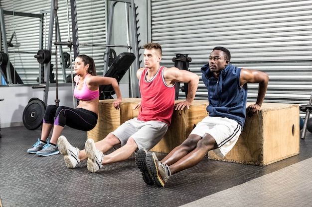 Ajustement des personnes faisant de l&#39;exercice ensemble au gymnase de crossfit