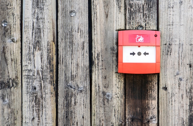 Alarme incendie rouge sur le fond de mur en bois