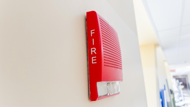 Une alarme incendie rouge sur un mur blanc