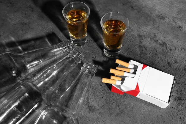 Alcool et cigarettes sur fond gris