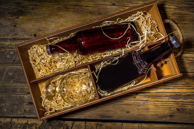 alcool spiritueux artisanal. Diverses bouteilles et verres avec des boissons alcoolisées fortes fabriquées à la main. Espace de copie de fond rustique en bois ancien