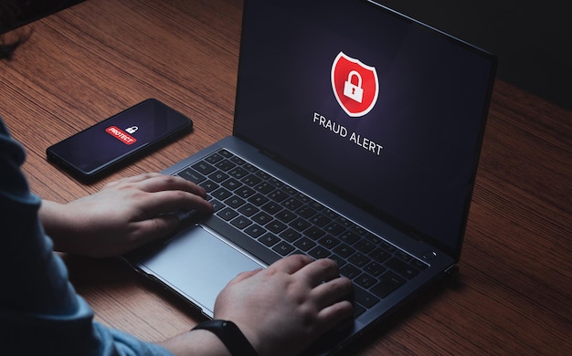 Alerte d'avertissement de piratage du système sur un ordinateur portable et un smartphone Alerte de fraude sur l'écran d'un appareil numérique Attention