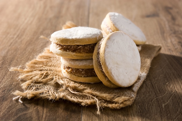 Alfajores argentines traditionnelles avec dulce de leche et sucre sur table en bois