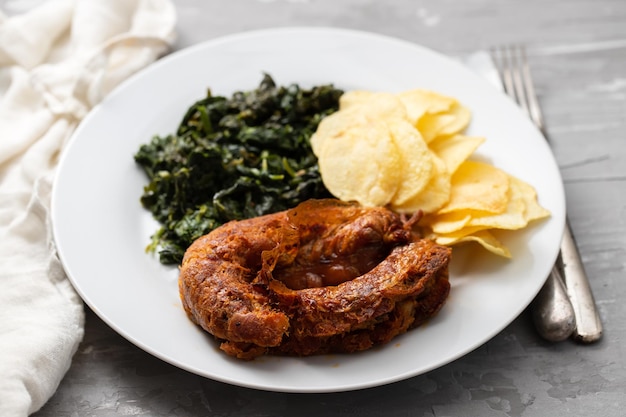 Alheira de saucisse fumée portugaise typique avec frites et légumes verts