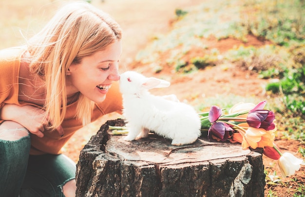 Alice au pays des merveilles. Lapin de Pâques. Belle femme tient un lapin blanc. Joyeuses Pâques.