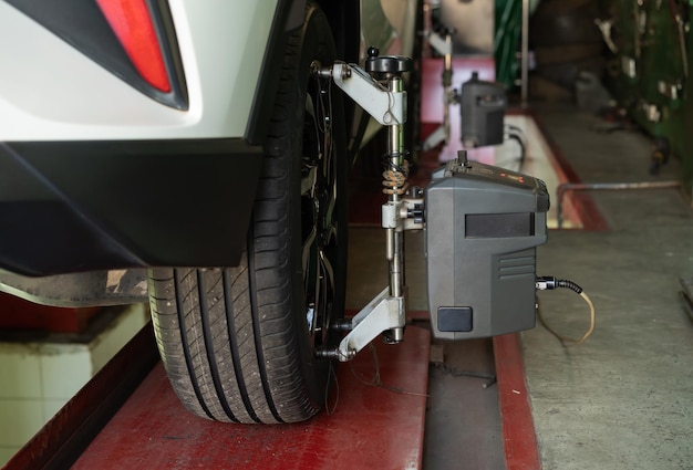 Alignement des roues de voiture en cours à la station-service de réparation automobile