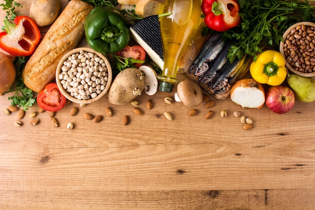 Alimentation équilibrée. Diète méditerranéenne. Fruits, légumes, céréales, noix huile d'olive et poisson sur table en bois Vue de dessus Copyspace