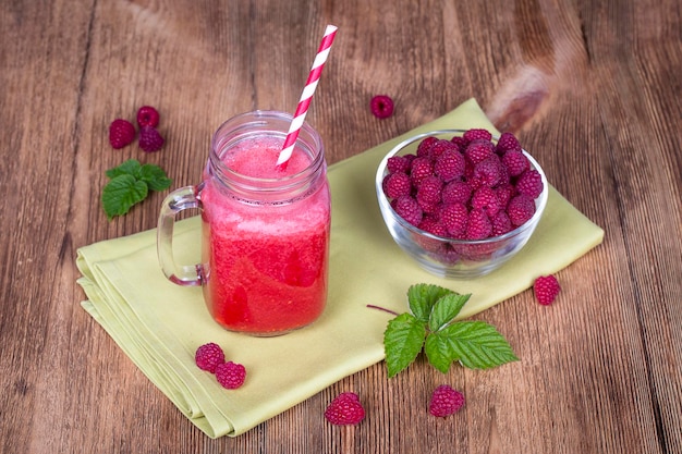 Alimentation saine alimentation diététique et concept végétarien tasse de verre de jus smoothie shake à partir de framboises et framboises crues sur fond de bois de près