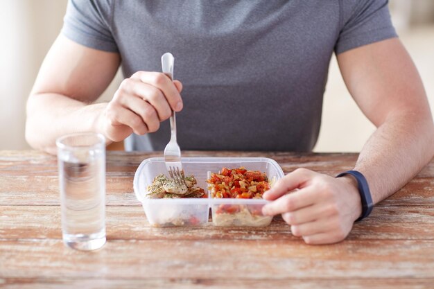 alimentation saine, alimentation équilibrée, concept de nourriture et de personnes - gros plan de mains masculines ayant de la viande et des légumes pour le dîner avec une fourchette et un verre d'eau