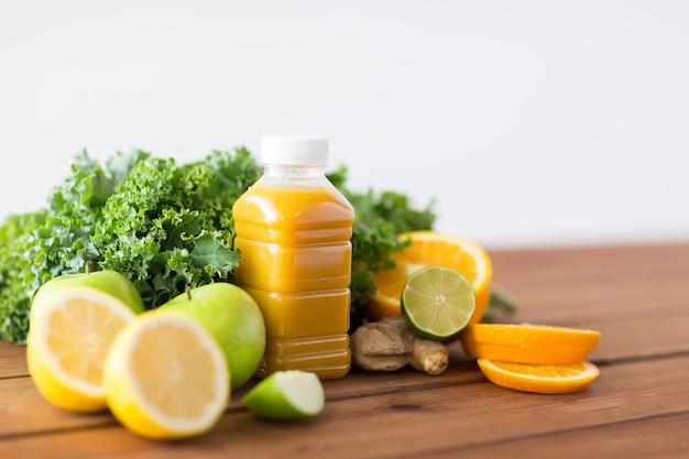 alimentation saine, alimentation, régime et concept végétarien - bouteille avec jus d'orange, fruits et légumes sur table en bois