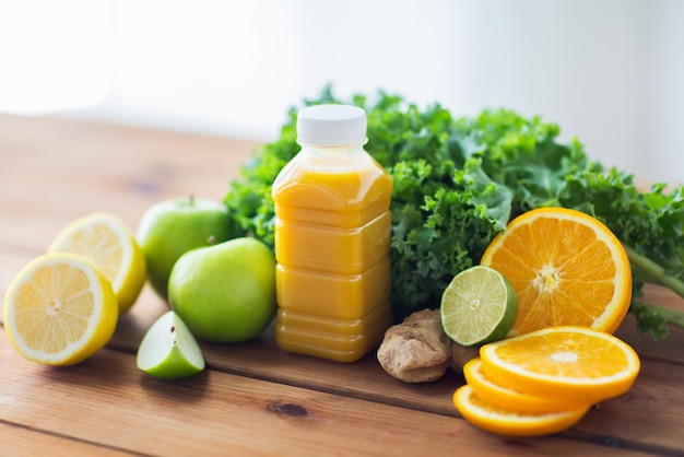 alimentation saine, alimentation, régime et concept végétarien - bouteille avec jus d'orange, fruits et légumes sur table en bois