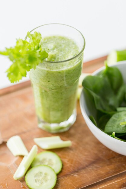 alimentation saine, aliments biologiques et concept de régime alimentaire - gros plan de jus vert frais avec du céleri sur une table en bois