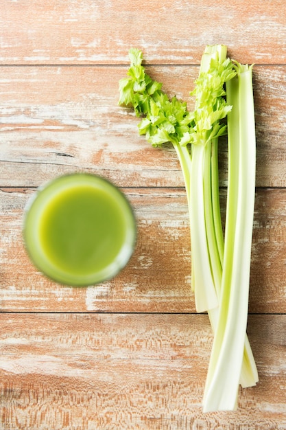 alimentation saine, aliments biologiques et concept de régime alimentaire - gros plan de jus vert frais avec du céleri sur une table en bois