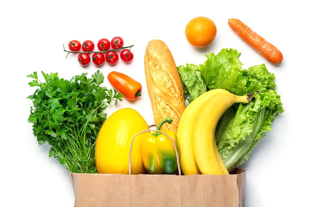 Alimentation saine dans un sac à provisions. Légumes, assortiment de fruits et verdure isolés sur fond blanc. Concept d'aliments sains végétariens.
