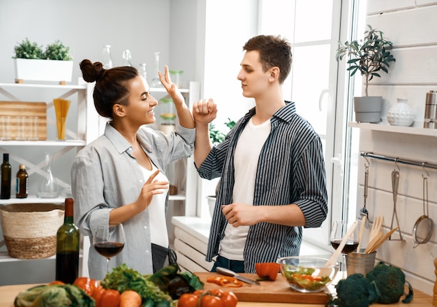 Alimentation saine à la maison. Un couple d'amoureux heureux prépare le bon repas dans la cuisine.