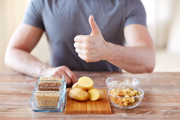 alimentation saine, régime alimentaire, geste et concept humain - gros plan des mains masculines montrant les pouces vers le haut avec des aliments glucidiques sur la table