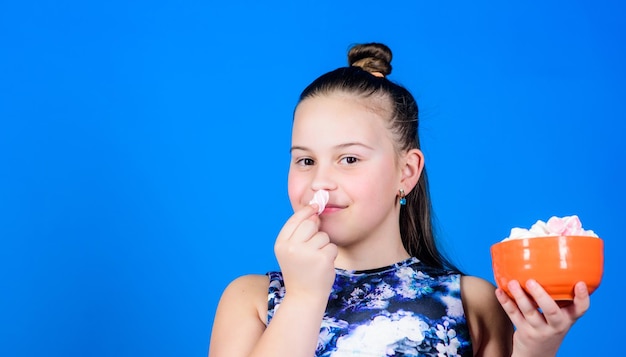 Alimentation saine et soins dentaires Petite fille mange de la guimauve à la guimauve Bonbons heureux petit enfant aime les bonbons et les friandises Régime et calories Concept de dent sucrée copie espace soins dentaires