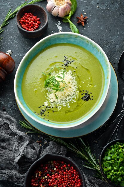 Alimentation saine Soupe verte au brocoli et aux épinards dans une assiette sur fond de pierre noire Vue de dessus Style rustique