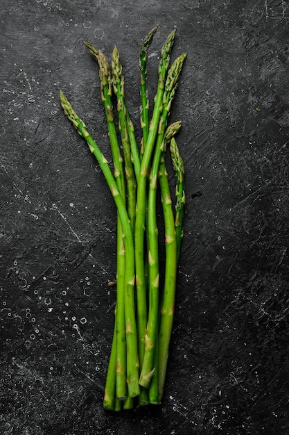 Aliments biologiques Asperges vertes sur une table en pierre noire Sur un fond de pierre Vue de dessus