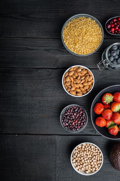 Aliments biologiques pour une alimentation saine et superaliments à plat avec un espace pour le texte sur fond de bois noir