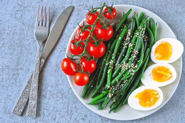 Aliments colorés et sains. flatlay. Bol de Bouddha avec des œufs, des haricots verts et des tomates cerises.