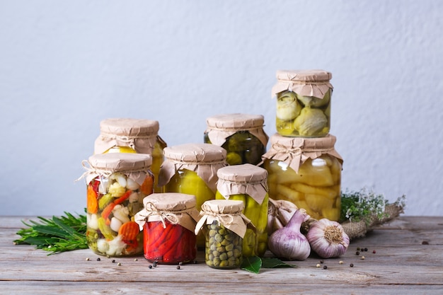 Aliments conservés et fermentés. Assortiment de pots faits maison avec une variété de légumes marinés et marinés sur une table en bois. Entretien ménager, économie domestique, préservation des récoltes