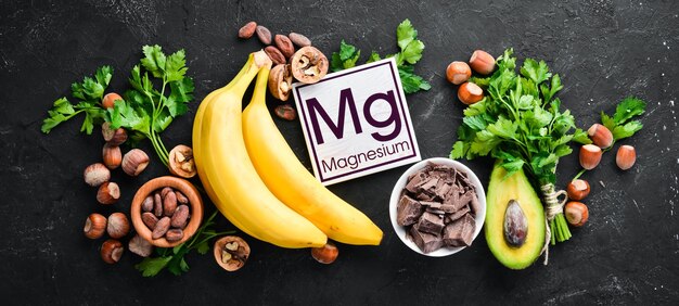 Aliments contenant du magnésium naturel Mg Chocolat Banane Noix de cacao Avocats Brocoli Amandes Vue de dessus Sur fond noir