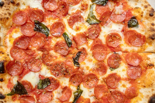Aliments diététiques gras nocifs. Pizza aux saucisses pepperoni, fromage, basilic et épices