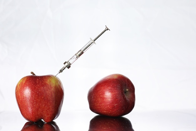 Aliments génétiquement modifiés, pomme pompée avec des produits chimiques à partir d'une seringue