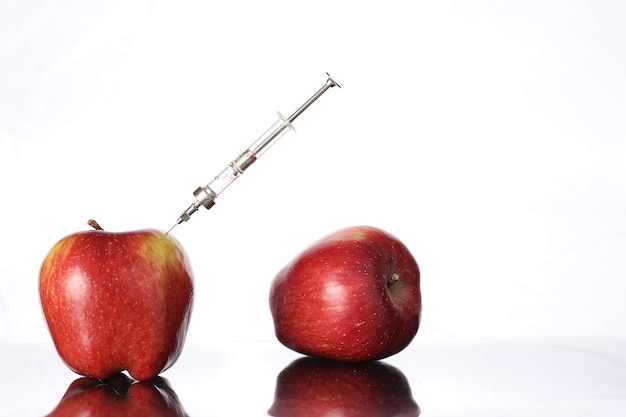 Aliments génétiquement modifiés, pomme pompée avec des produits chimiques à partir d'une seringue