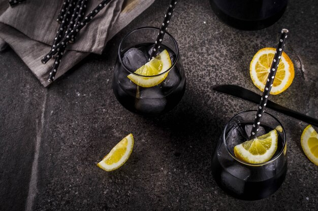 Aliments à la mode Boissons rafraîchissantes d'été Concept de désintoxication et de régime Limonade noire avec du jus de citron au charbon et du citron