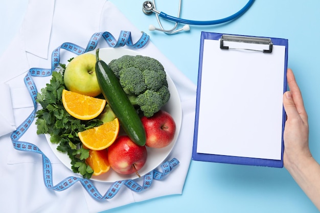 Aliments sains et accessoires de médecins sur la perte de poids de fond bleu