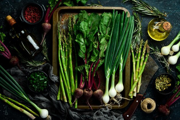 Aliments sains biologiques Asperges fraîches oignons verts et betteraves rouges sur une table de cuisine en pierre Légumes style rustique