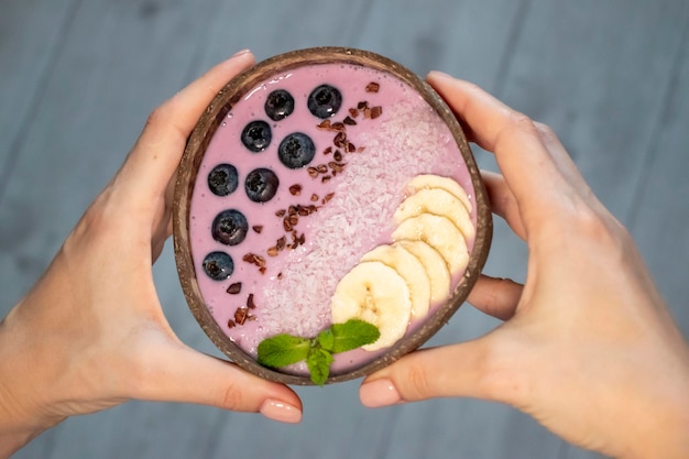 Aliments sains colorés dans un bol avec des superaliments caillé de fruits idée de petit-déjeuner Keto et de la nourriture végétalienne Femme tenant un bol de bleuets dans ses mains